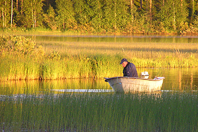 Fiskare i båt i ett varmt, gyllene ljus