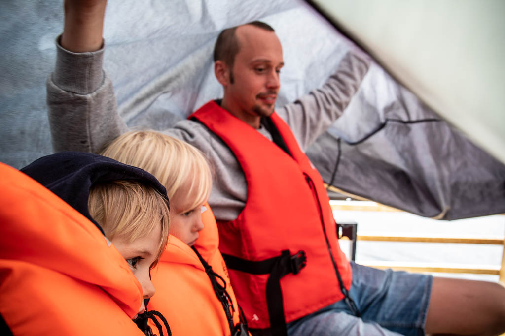 Tore, Signe och Markus med möbelöverdrag som regnskydd