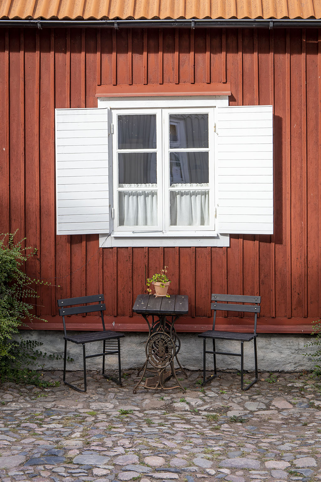 Sittgrupp framför husvägg